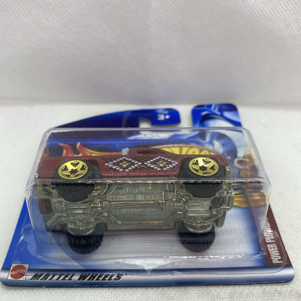 Hot Wheels die-cast pickup in blister pack, side view of maroon flame truck with yellow wheels
