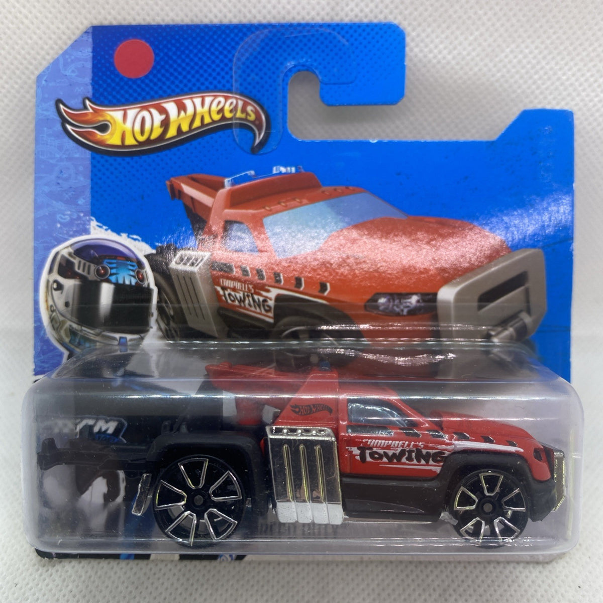 Red and orange die-cast tow truck on Hot Wheels card, 1:64 scale.