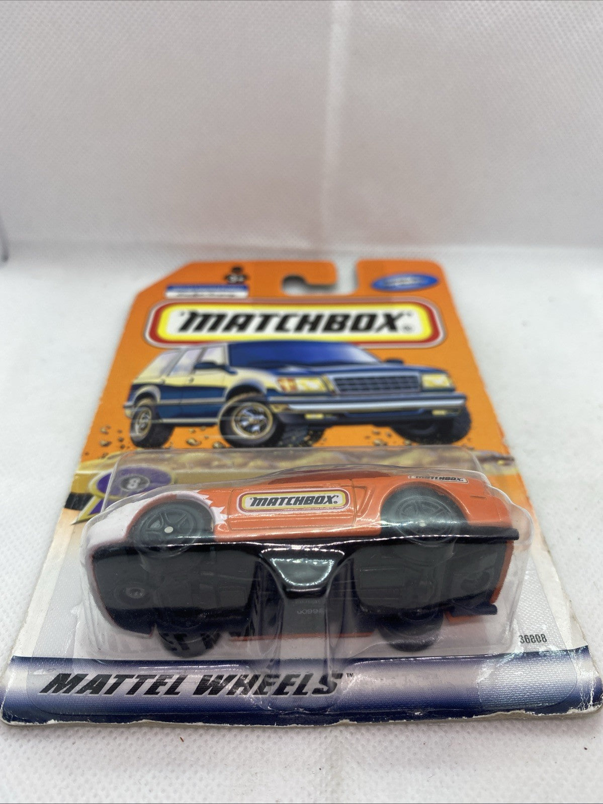 Sealed Matchbox die-cast car blister showing orange 1999 Mustang side view