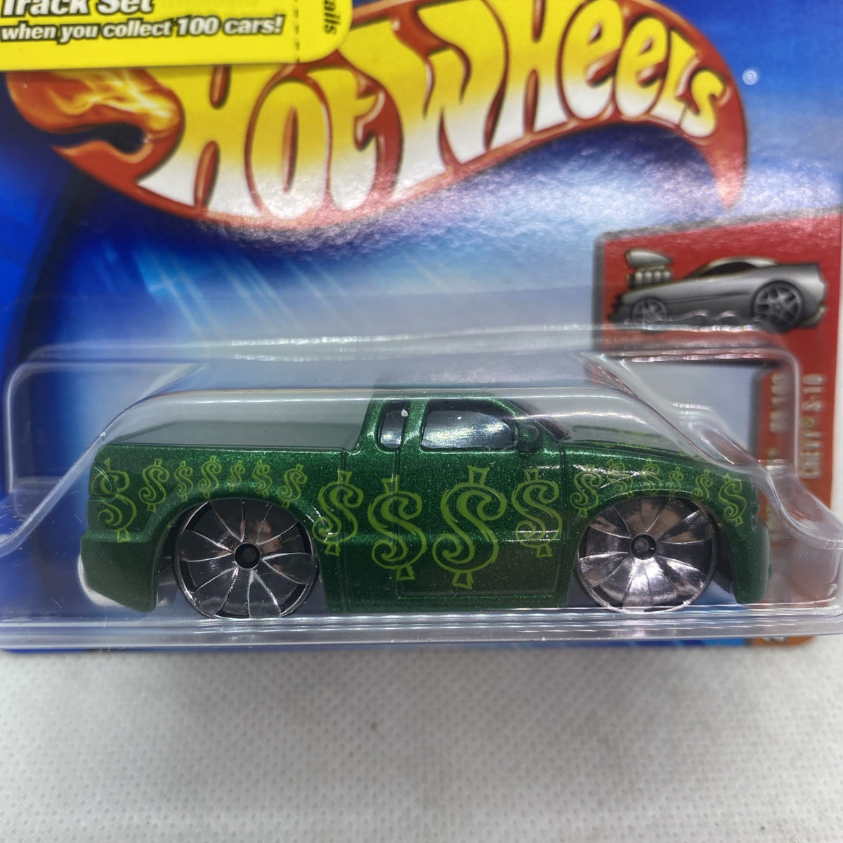 Hot Wheels green die-cast truck with black wheels in clear blister, close-up