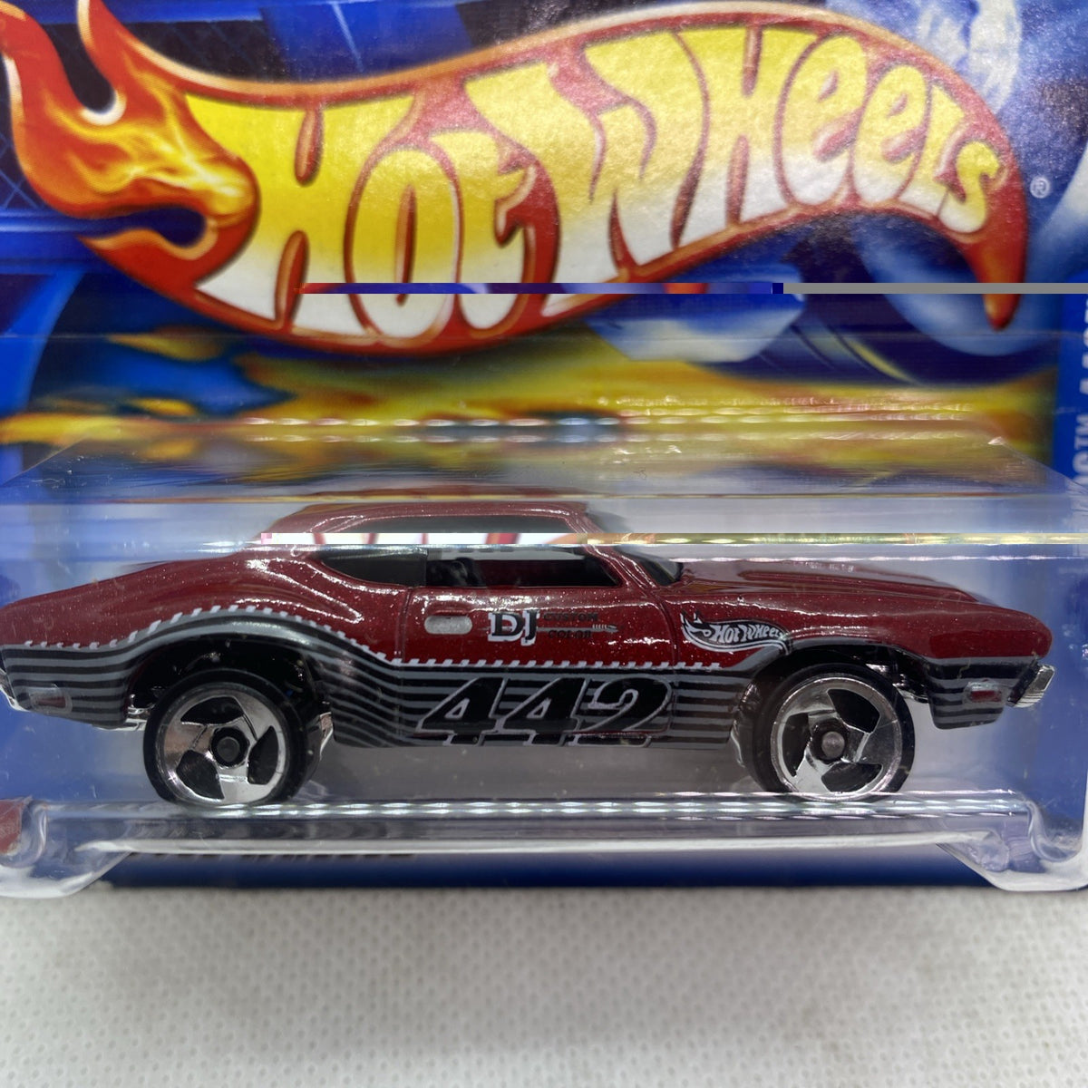 Hot Wheels maroon Olds 442 die-cast close-up inside blister card with flame logo