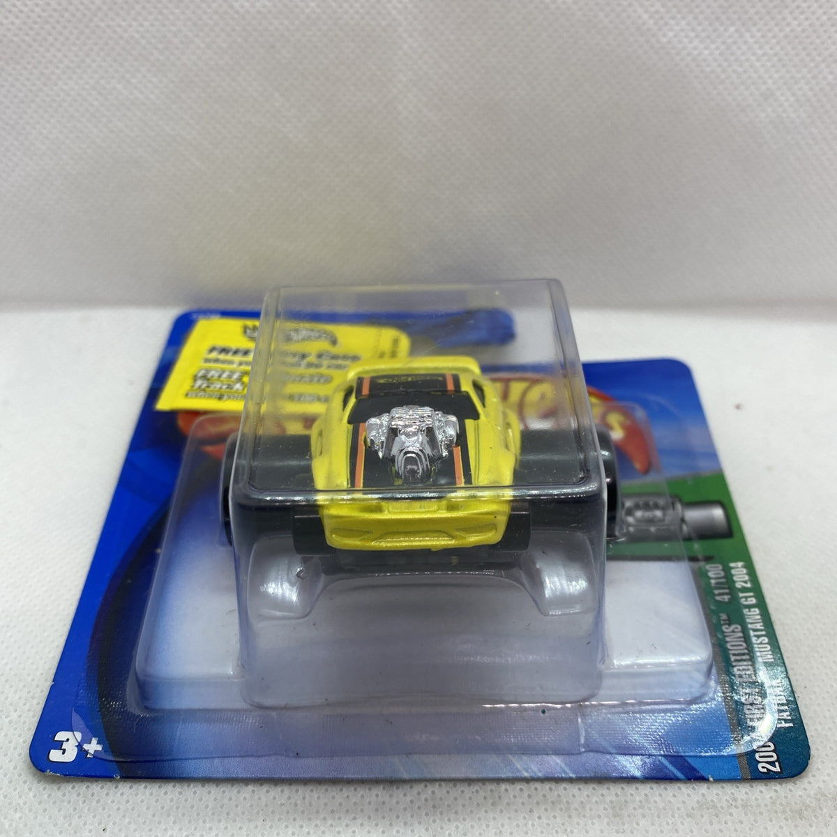 Yellow Mustang GT toy car in clear blister, angled side view on blue card