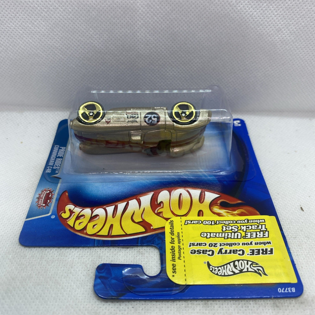 Gold die-cast race car in clear blister pack, side view on yellow Hot Wheels card