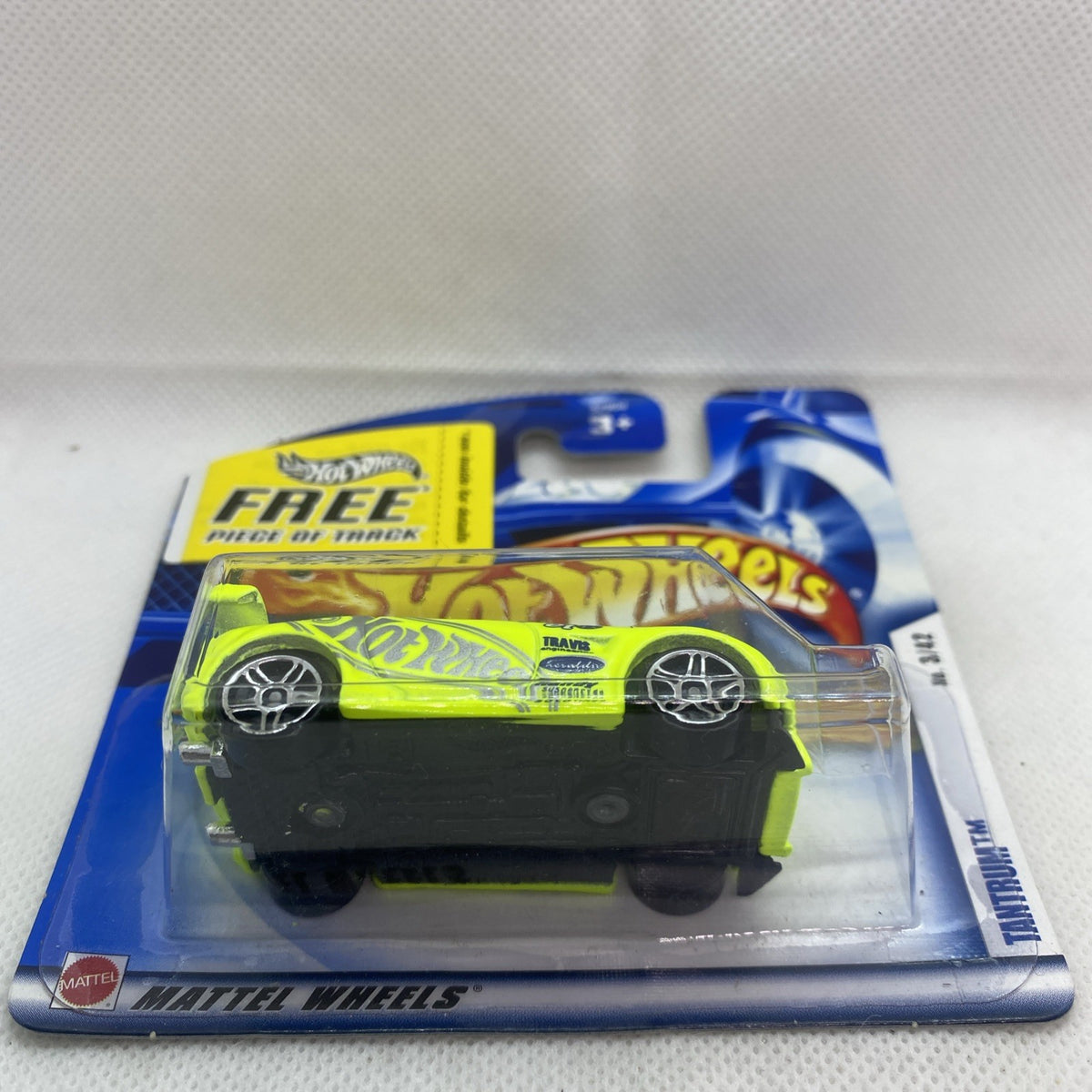 Hot Wheels carded neon lime die-cast car in clear blister, side view