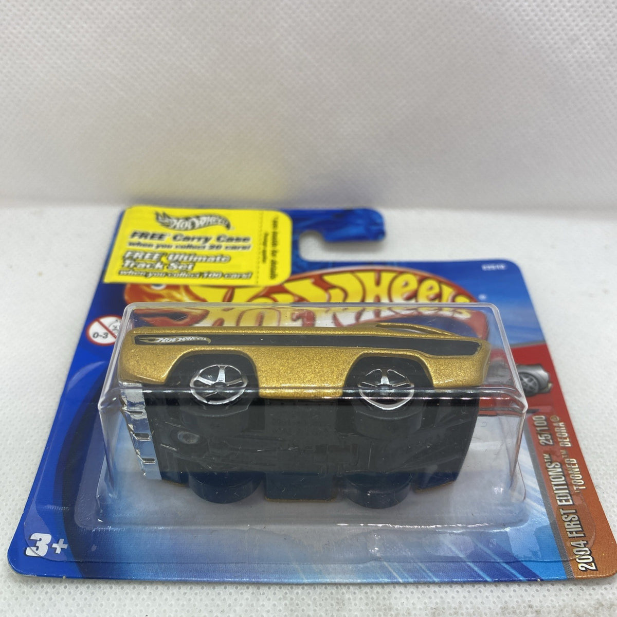 Gold and black Hot Wheels car in blue blister pack, front view, sealed