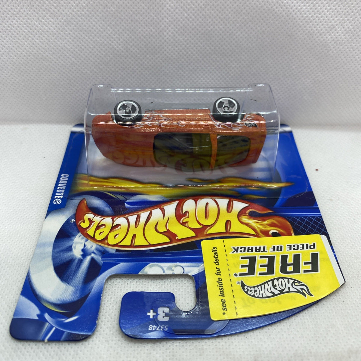 Orange die-cast Corvette toy car in clear blister pack on blue backing