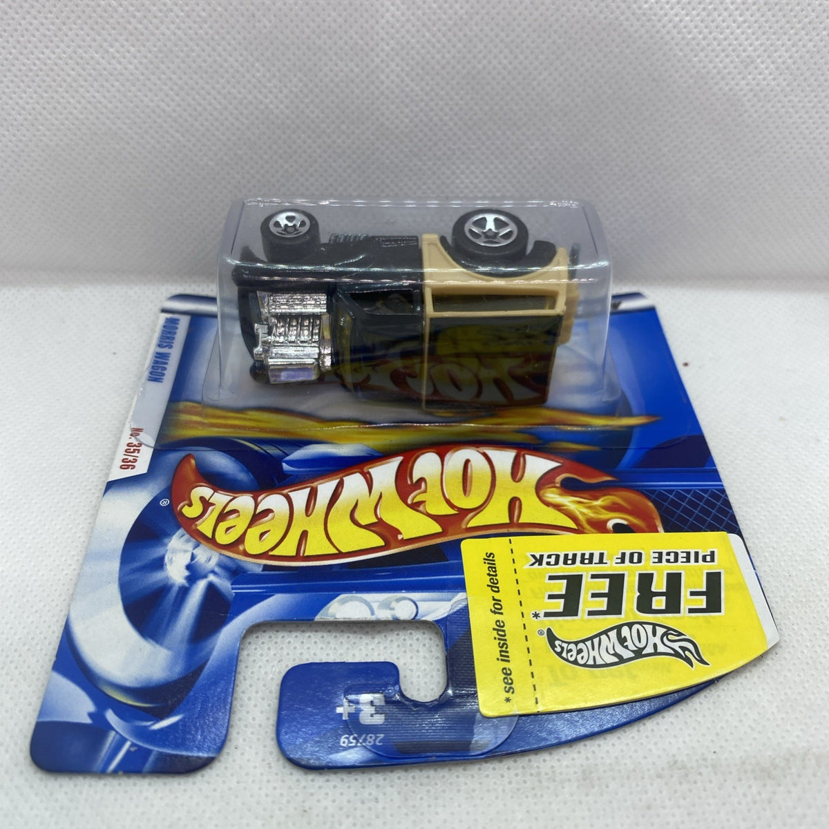 Black and tan Morris Wagon die-cast toy with silver engine detail in sealed blister