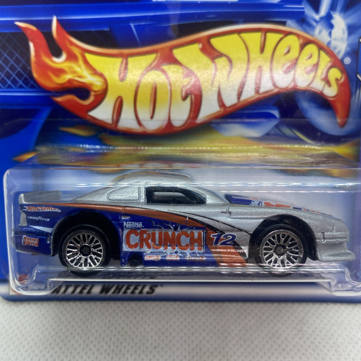 Hot Wheels silver sports car with black hood and “CRUNCH 12” on blue card blister