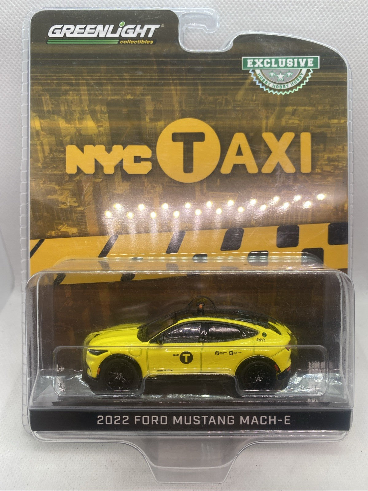 Yellow NYC Taxi die-cast car model in clear blister packaging.