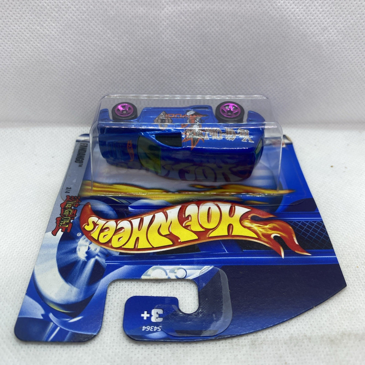 Hot Wheels blue blister pack with car in clear plastic, purple wheels visible.