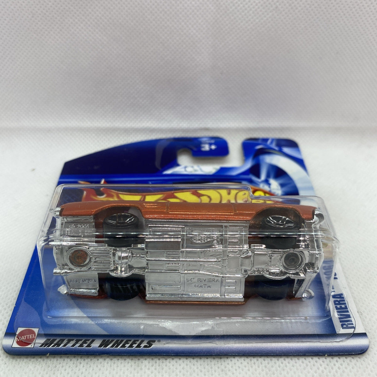 Orange classic die-cast car in clear blister pack with silver wheels, side view