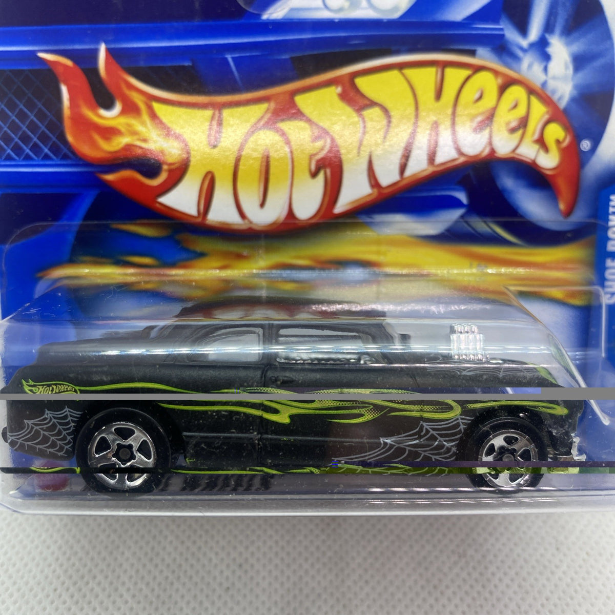 Hot Wheels die-cast car front close-up in blister, black body with neon green flames