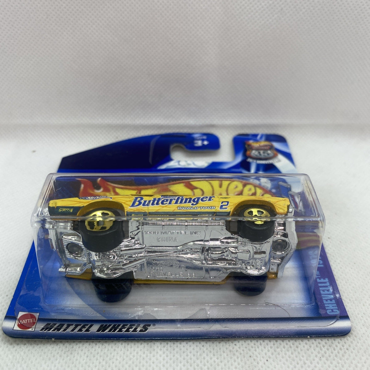 Hot Wheels die-cast yellow car blister pack, underside view with chrome engine detail