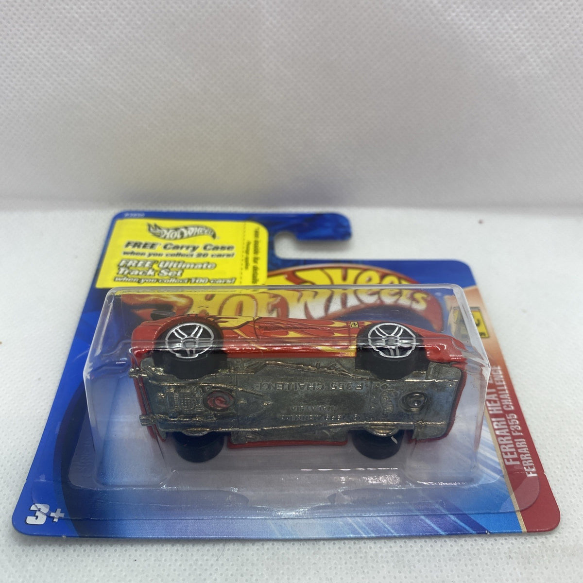 Hot Wheels Ferrari die-cast car underside in clear blister on blue backing card