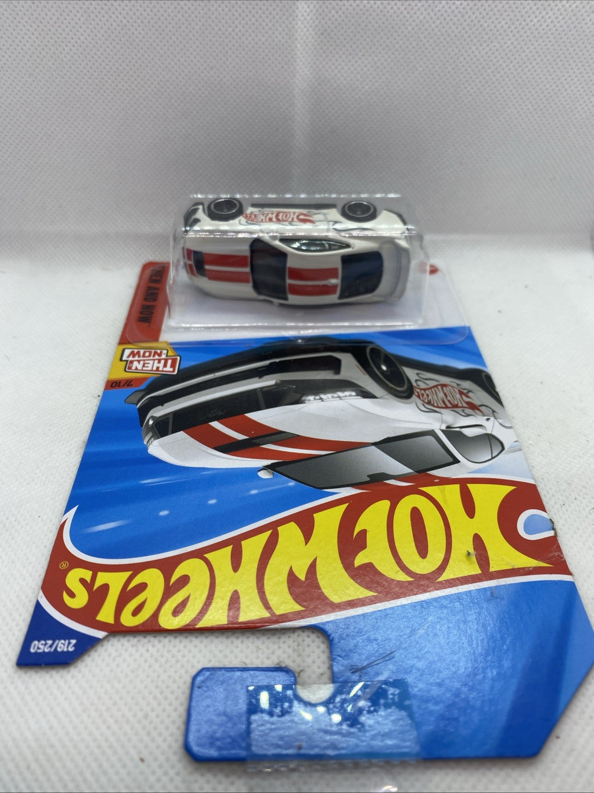 Hot Wheels car in blister pack, white with red stripe and black grille