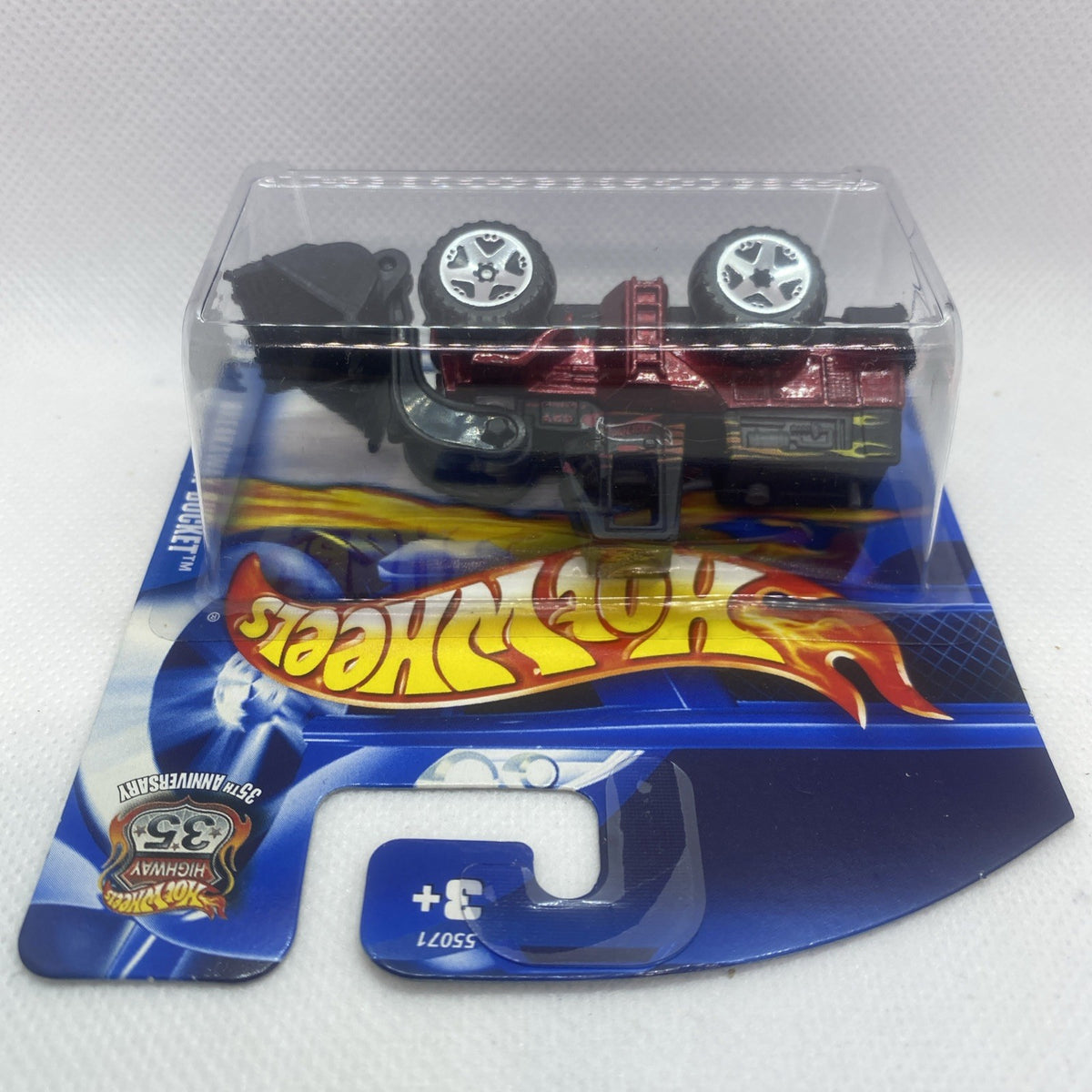 Hot Wheels toy truck with red cab, black tires, and clear blister on blue card