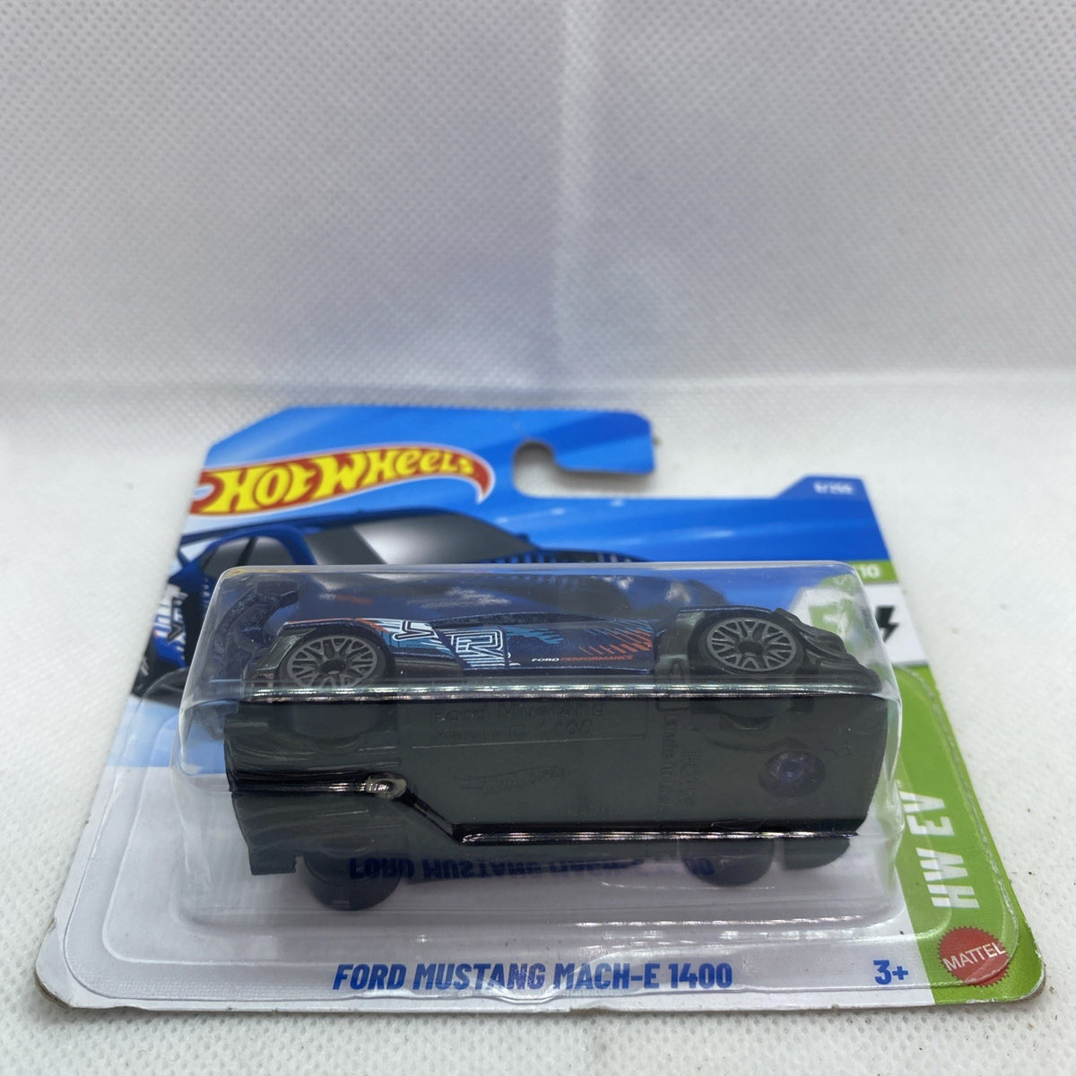 Blue and black Hot Wheels die-cast car on blister card, side view