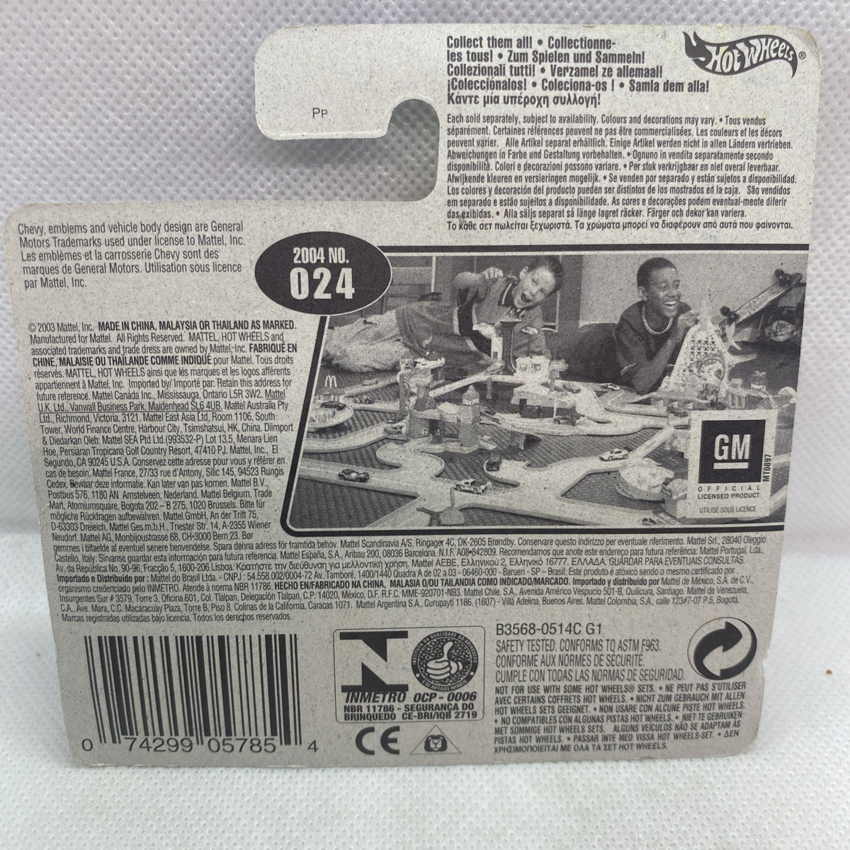 Toy die-cast car blister card back with barcode and GM image on gray background