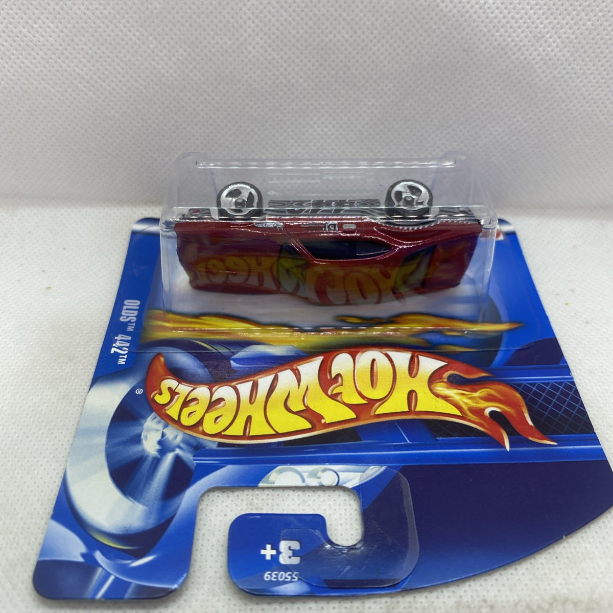 Hot Wheels car blister card front with clear cover, maroon vehicle inside