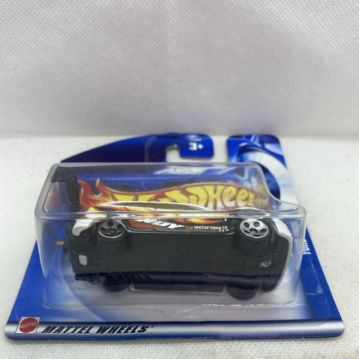 Hot Wheels die-cast Ford Focus car in blister pack, underside view with black chassis and wheels.