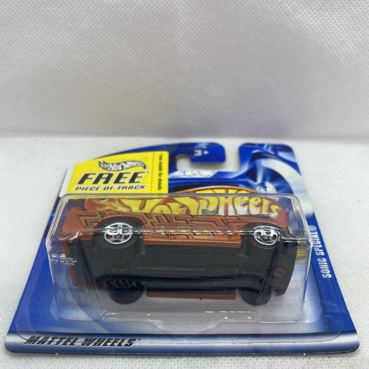 Hot Wheels mini truck on blue card with 'FREE piece of track' and blister