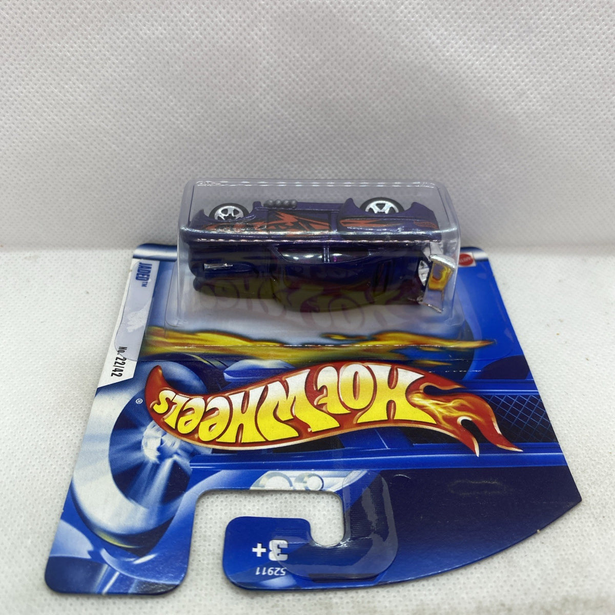 Hot Wheels die-cast car in blister pack, top view on blue backing
