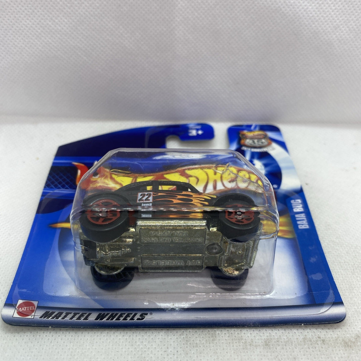 Die-cast toy car blister pack, front three-quarter view of black flame-decorated car.