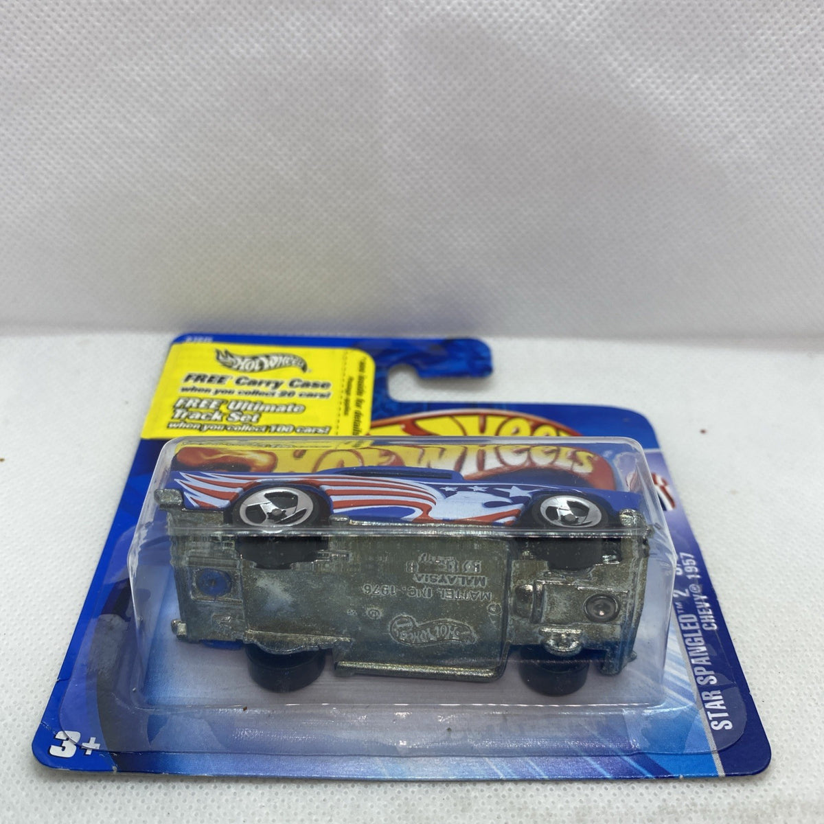 Hot Wheels 1957 Chevy die-cast car, blister showing underside detail