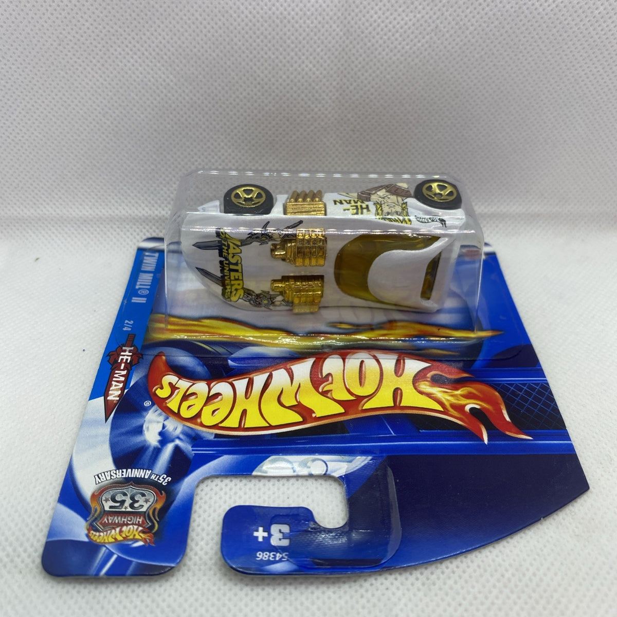 Hot Wheels die-cast car blister pack showing car underside, gold details and black wheels