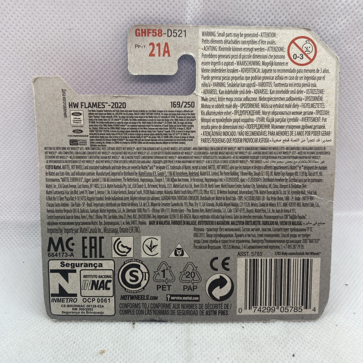 Hot Wheels car blister card back with product details, barcode, and safety icons