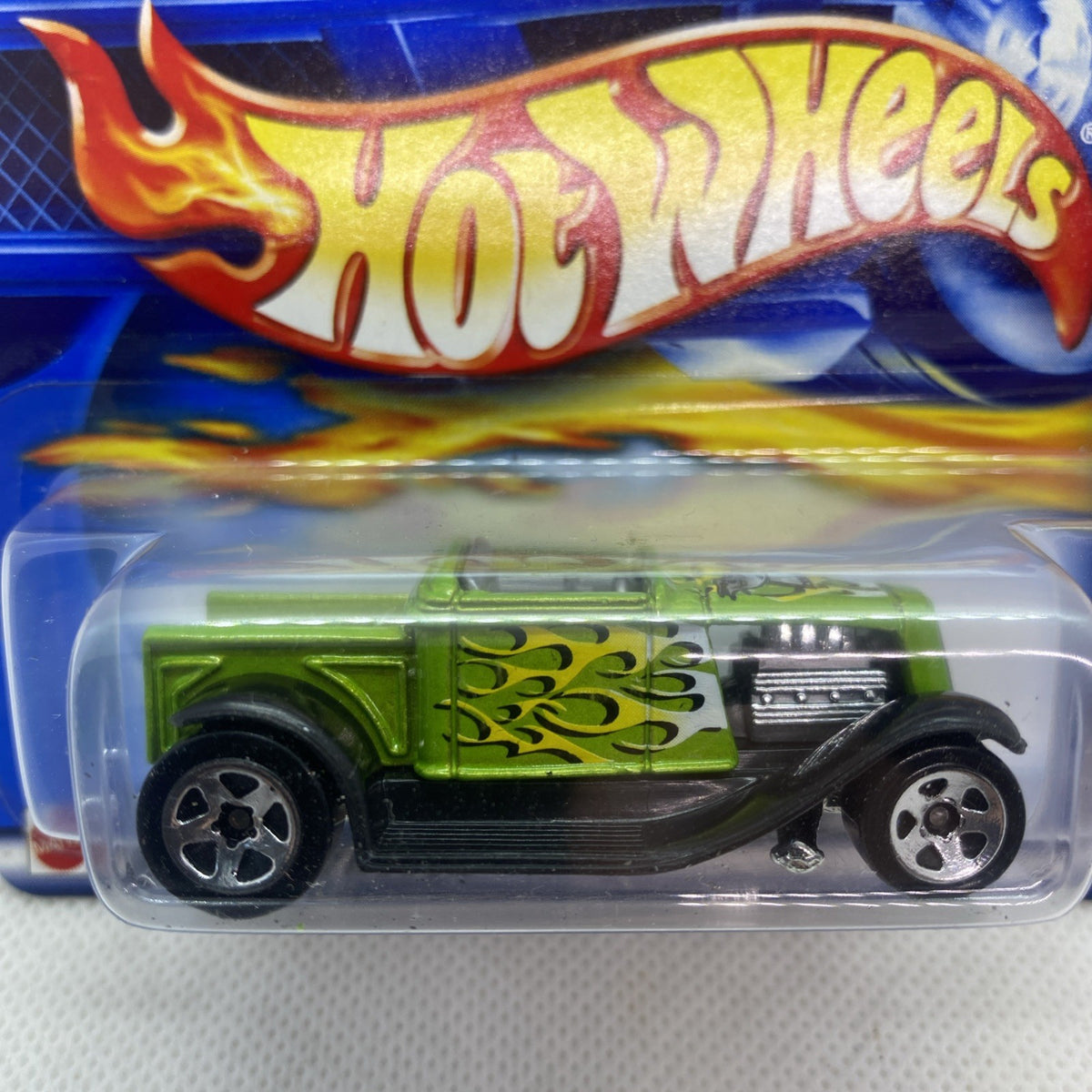 Hot Wheels Hooligan Hot Rod die-cast car close-up in blister, green body and flame decal.