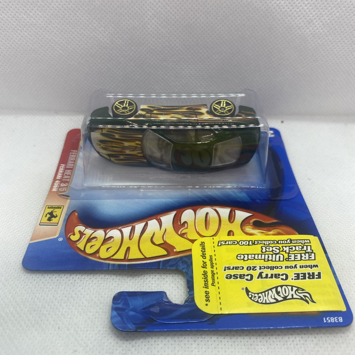Die-cast sports car in blister pack, green with gold flame stripe, rear/top view