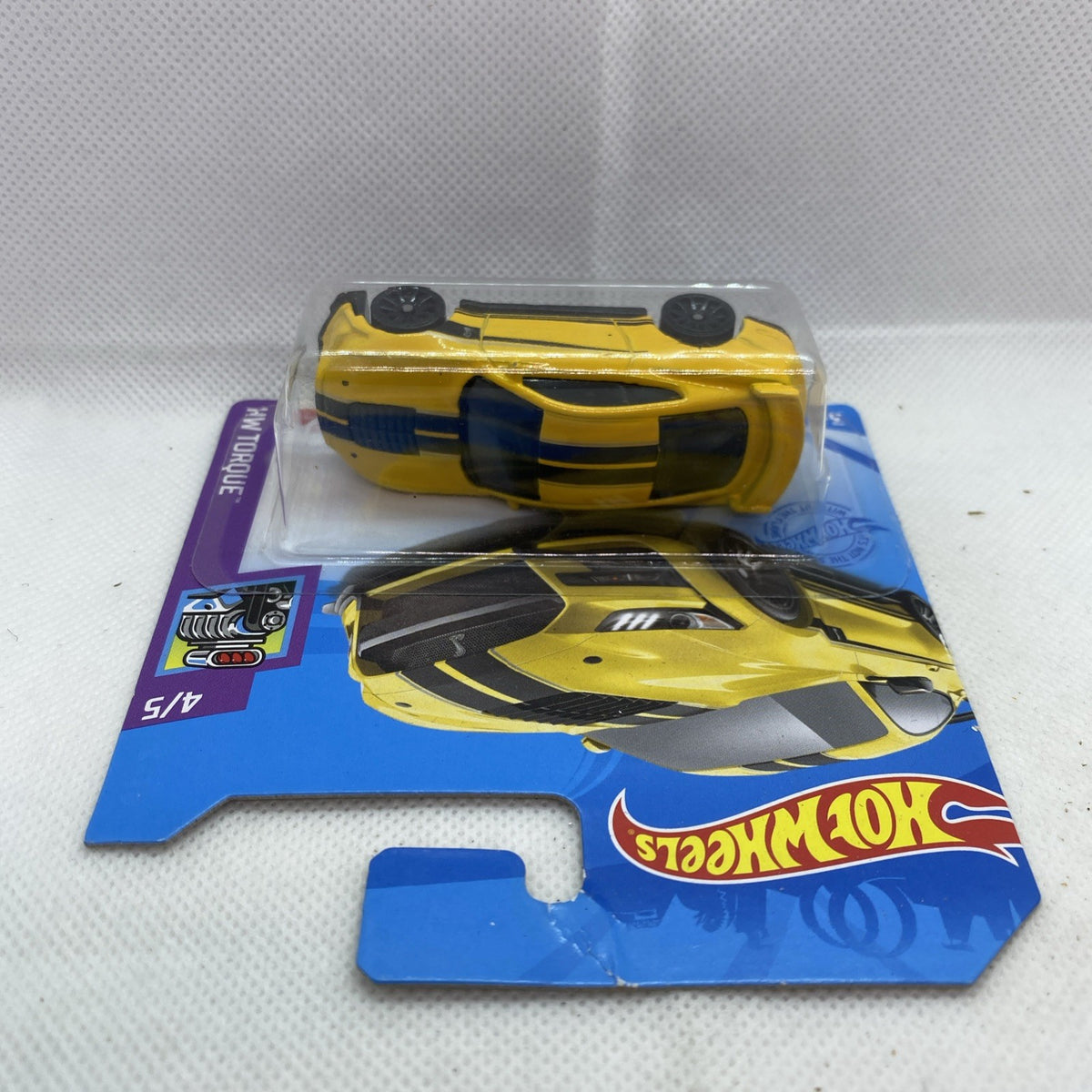 Yellow and black die-cast muscle car in blister, top-down view