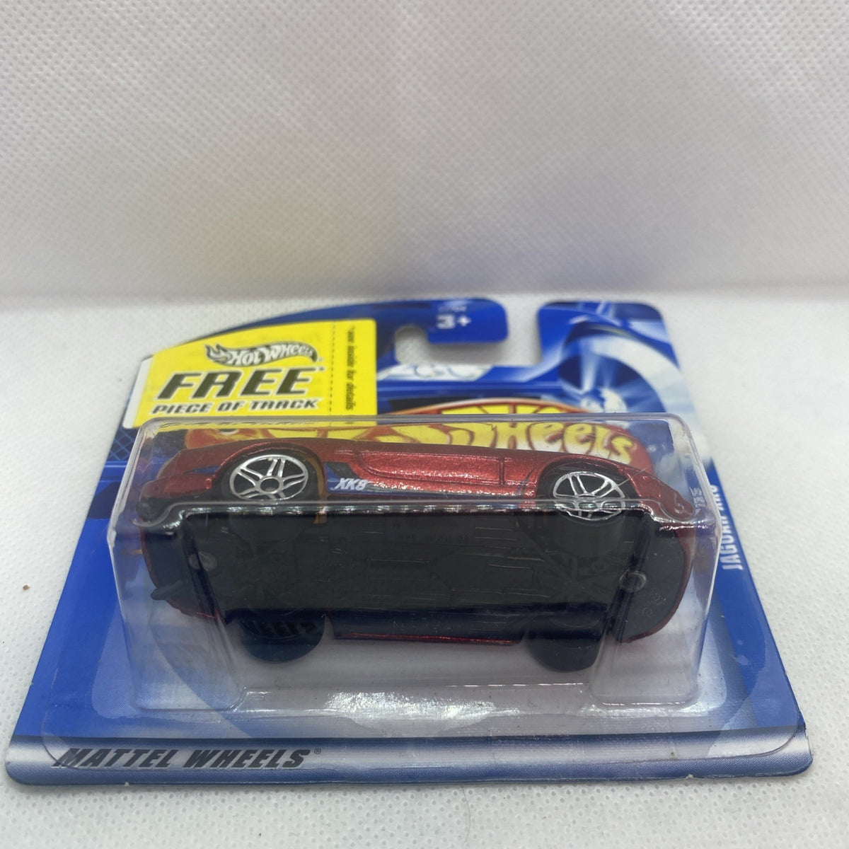Red die-cast Jaguar XK8 toy car in sealed Hot Wheels card, side view