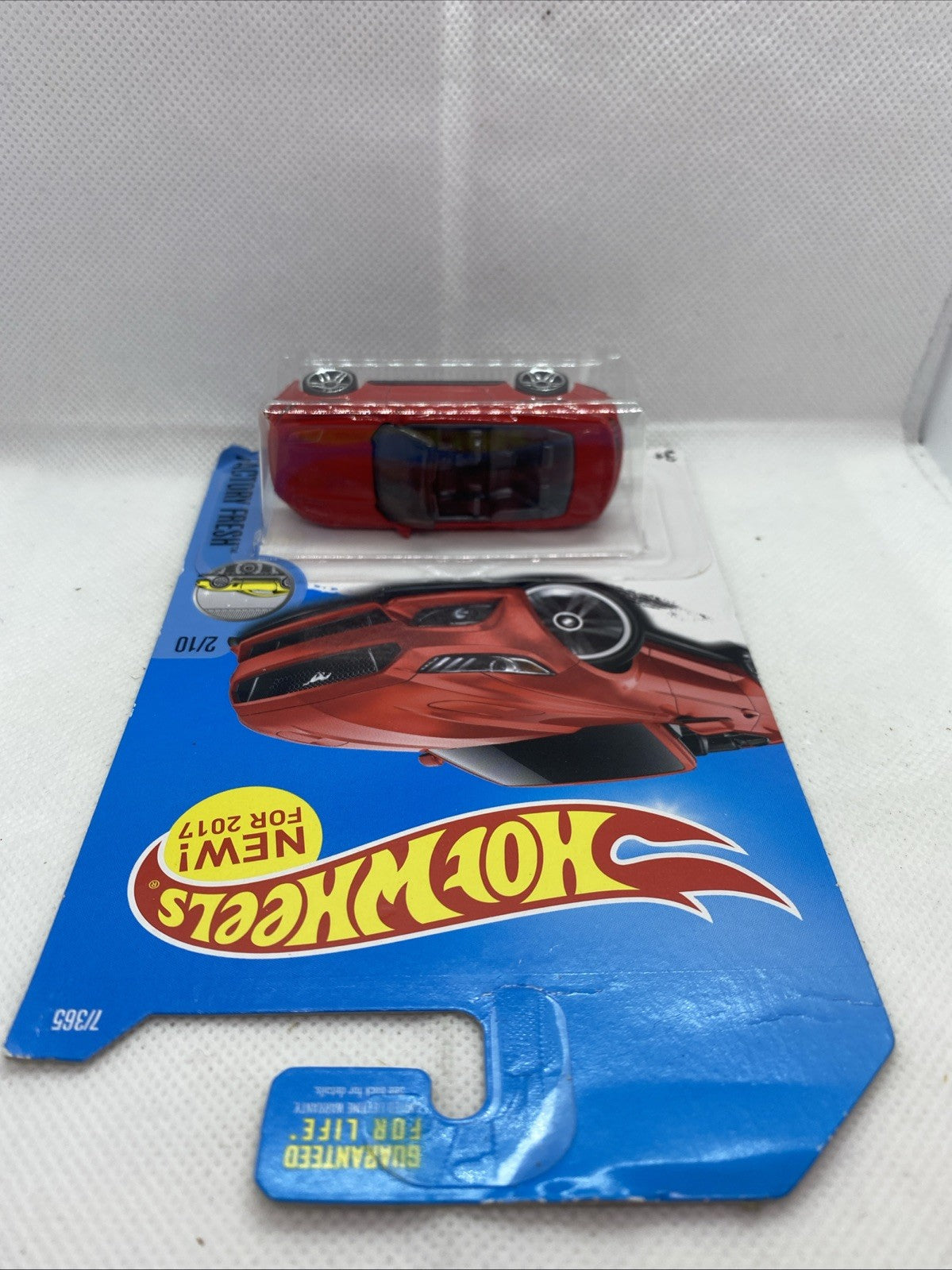 Hot Wheels red Mustang convertible toy on card, rear view through clear blister