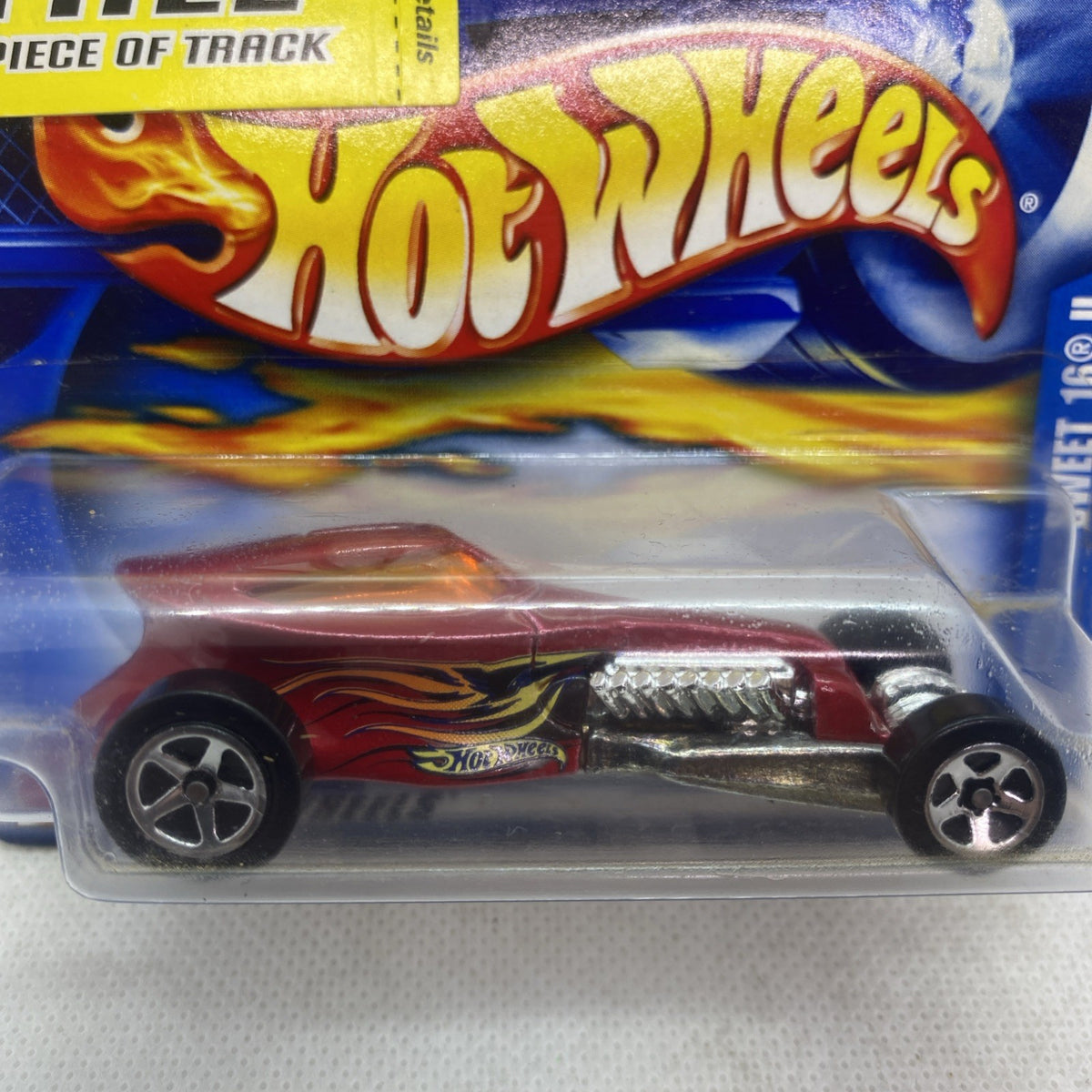 Hot Wheels die-cast car in blister pack, maroon flame graphics and silver exhaust