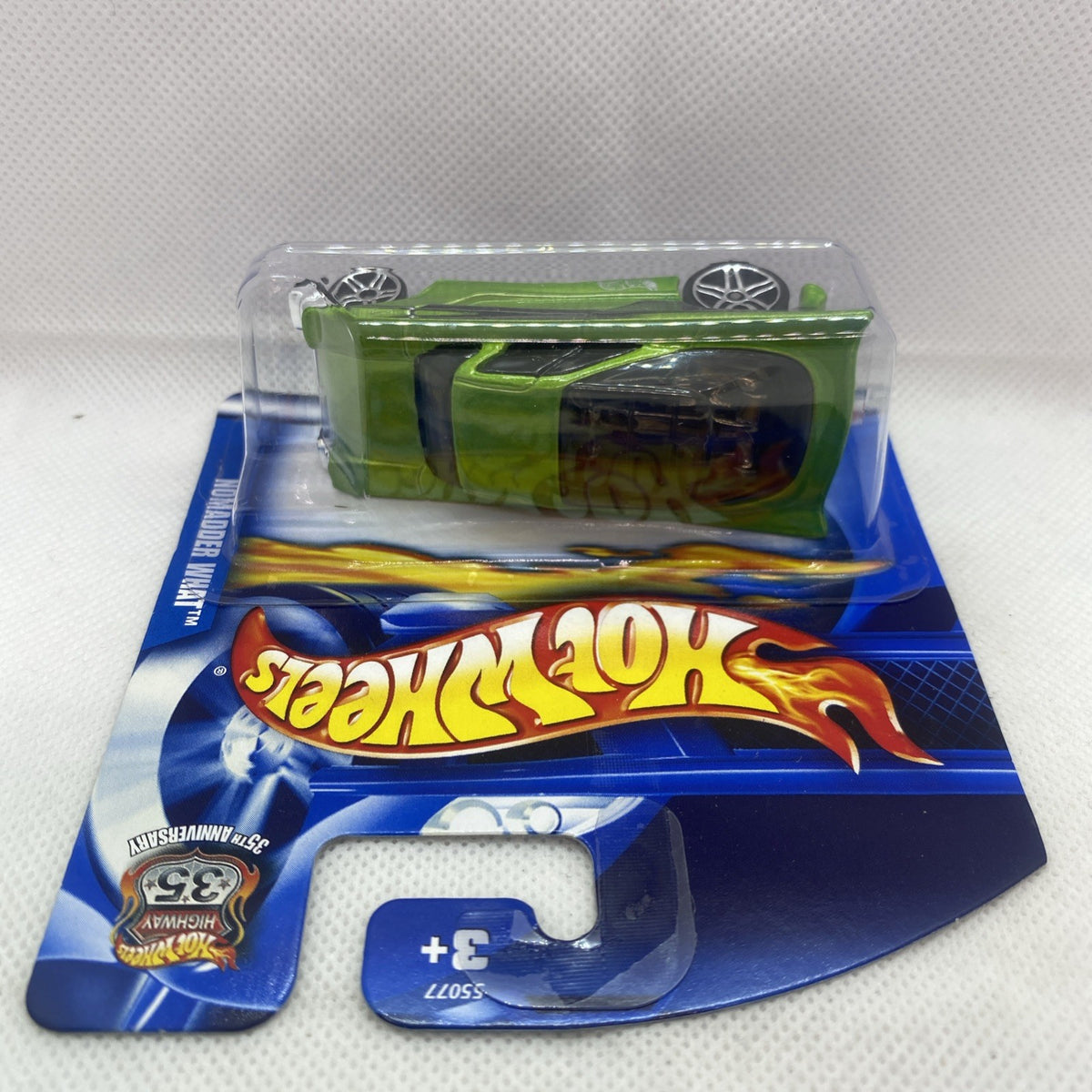 Green die-cast Hot Wheels car in clear blister on blue card, rear view