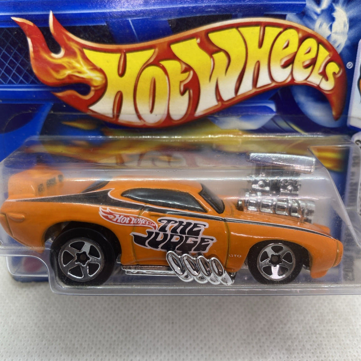 Close-up of sealed orange die-cast car toy in blister pack with Hot Wheels logo