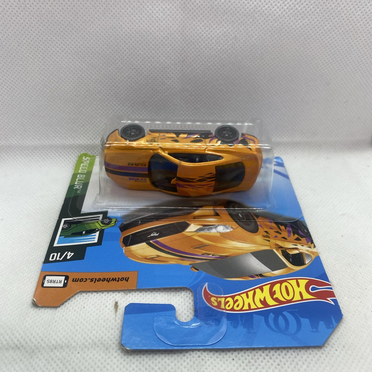 Orange Speed Blur die-cast car in clear blister on blue card, rear side view.