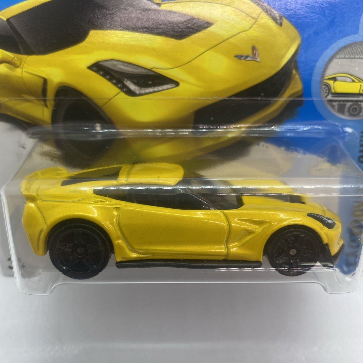 Close-up of yellow Hot Wheels diecast Corvette C7 Z06 with black hood and side stripe