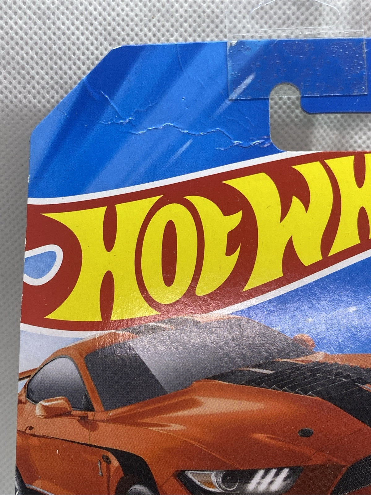 Hot Wheels blister pack with orange Mustang Shelby GT500 artwork and car window.
