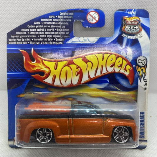Hot Wheels die-cast car in blister pack, orange body with chrome wheels and black windows.