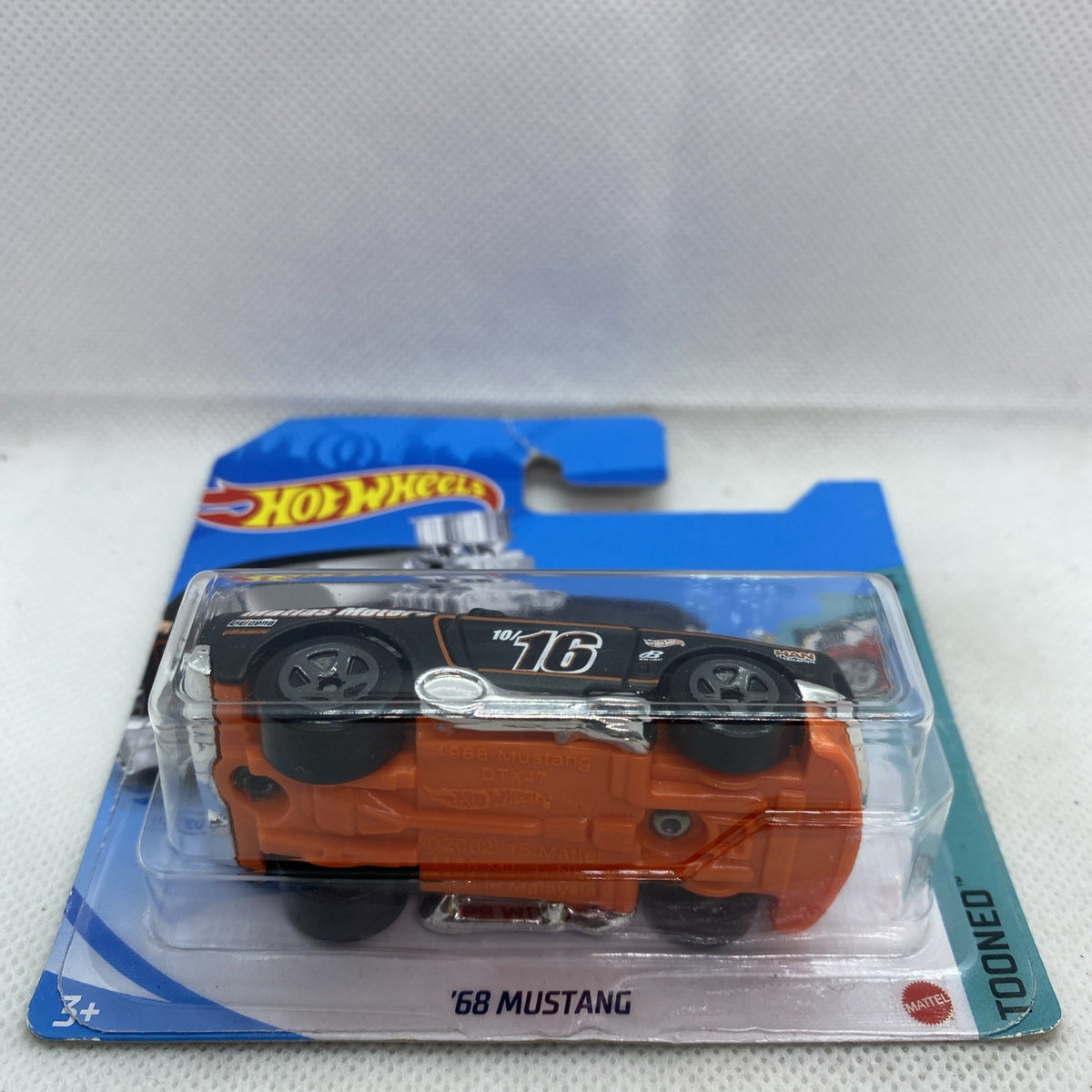 Hot Wheels ’68 Mustang die-cast car in clear blister, black top with orange body base