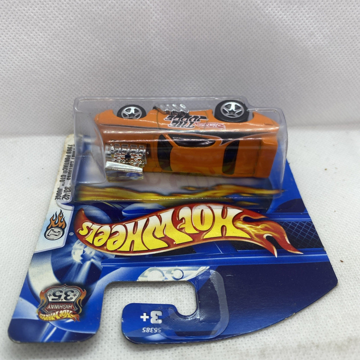 Orange die-cast car toy in clear blister with Hot Wheels flames graphics on card