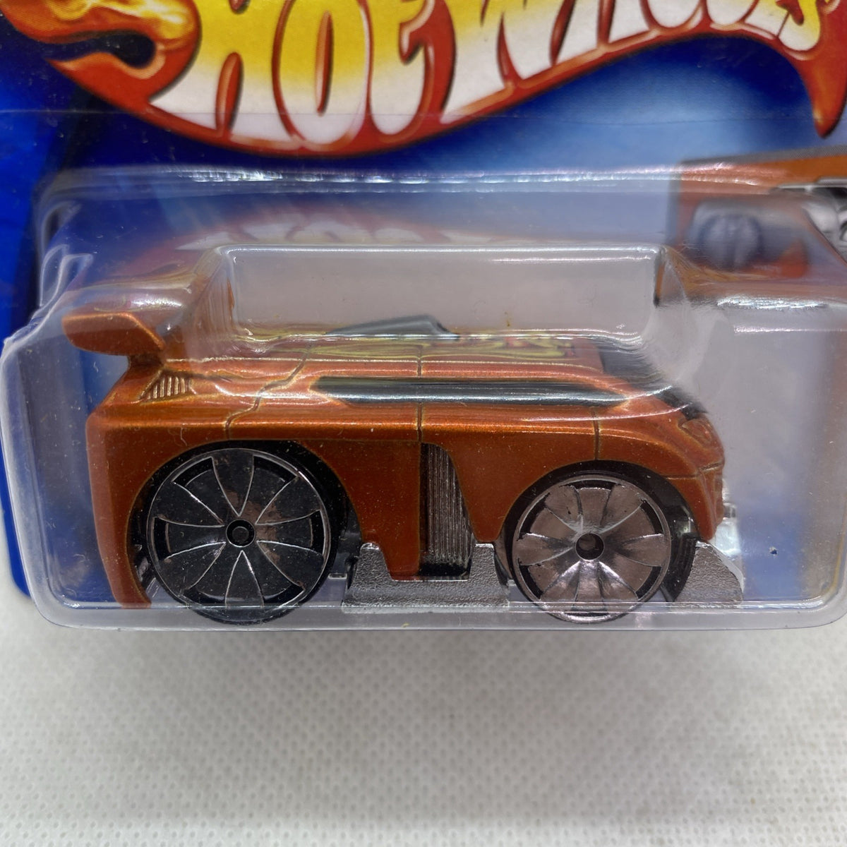 Hot Wheels die-cast orange-brown car close-up in clear blister package