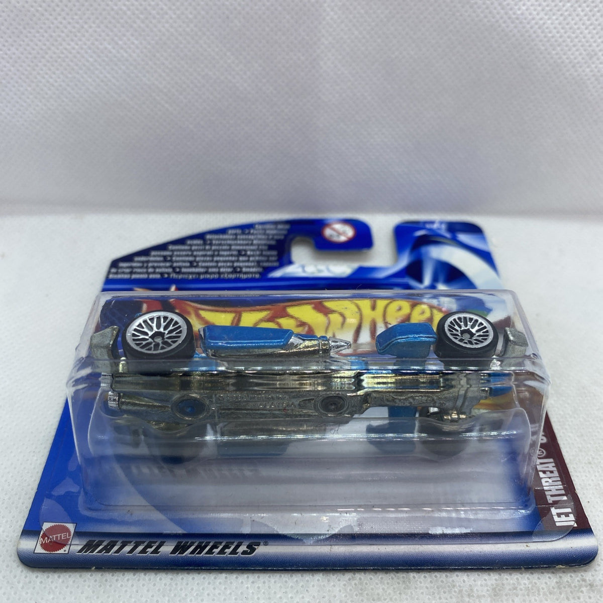 Die-cast race car in blister pack, front wheels and chassis visible