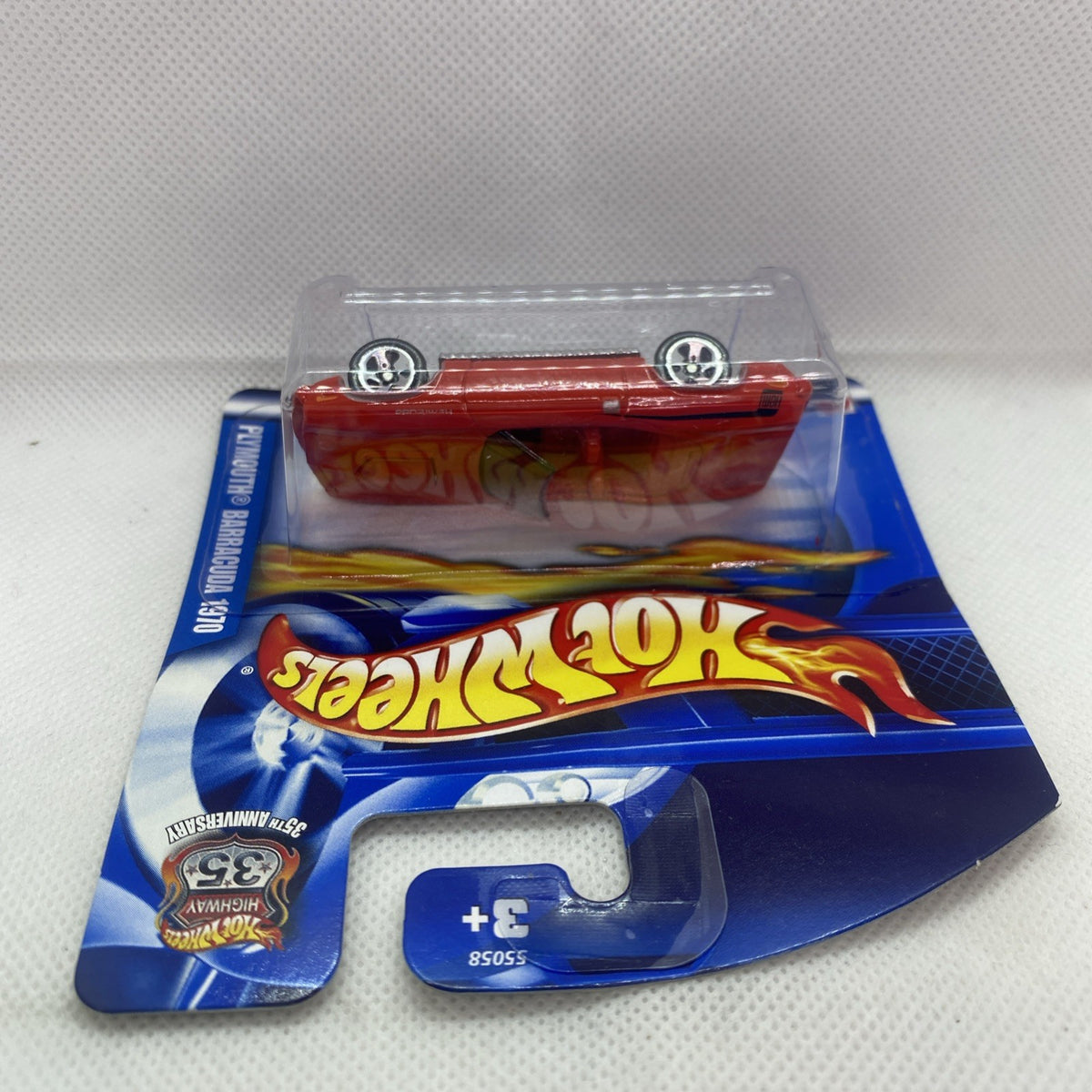 Red Hot Wheels car in clear blister pack on blue card with flame logo