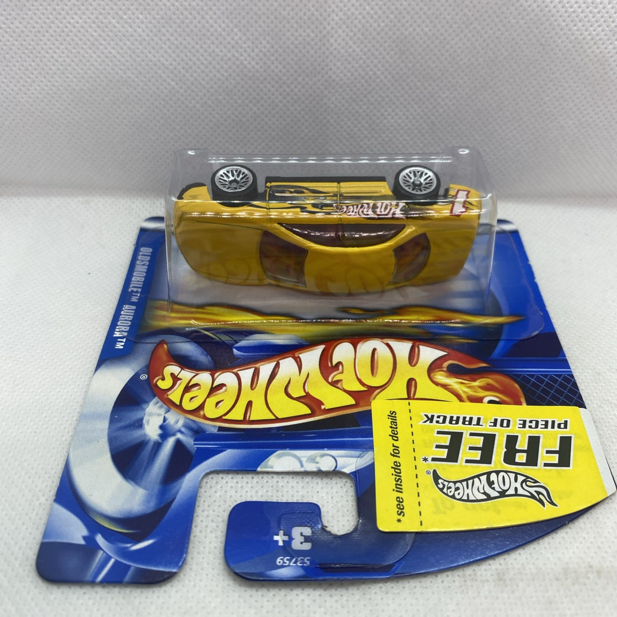 Hot Wheels Oldsmobile Aurora 2001 yellow die-cast car on blister card, top view