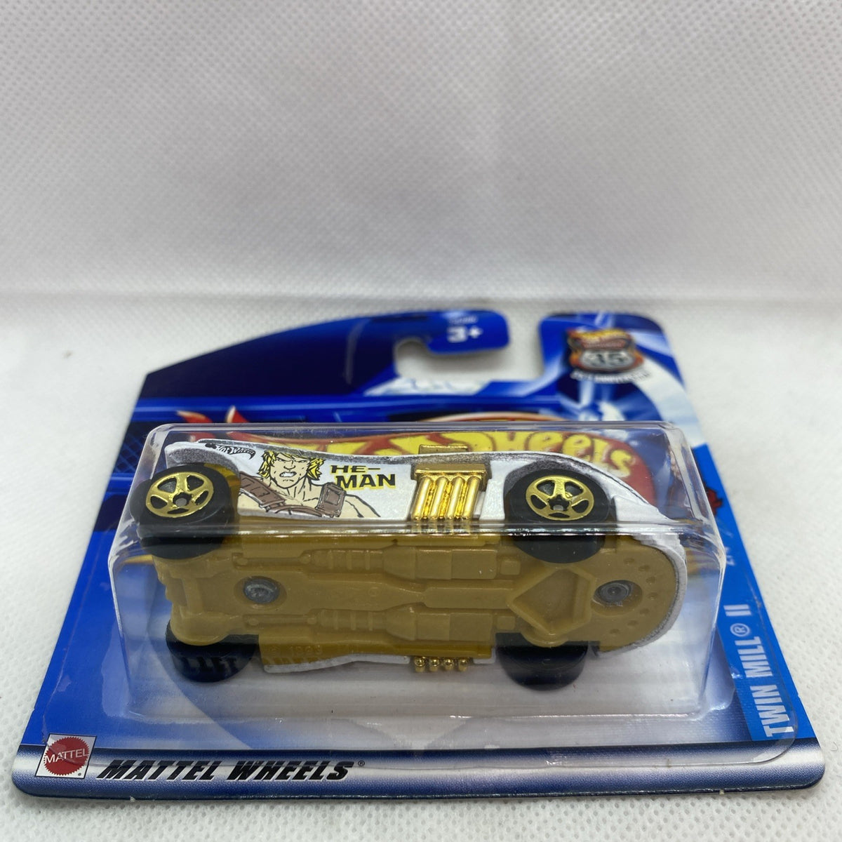 Hot Wheels die-cast car in sealed blister pack, side view with gold grille and He-Man graphics