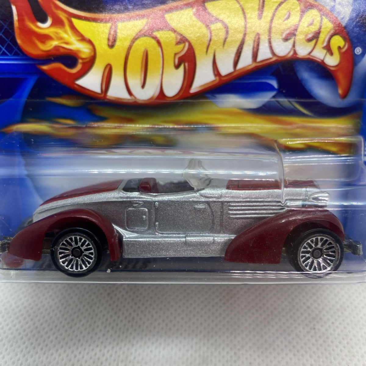Hot Wheels Auburn 852 die-cast car close-up, silver body with maroon wheels
